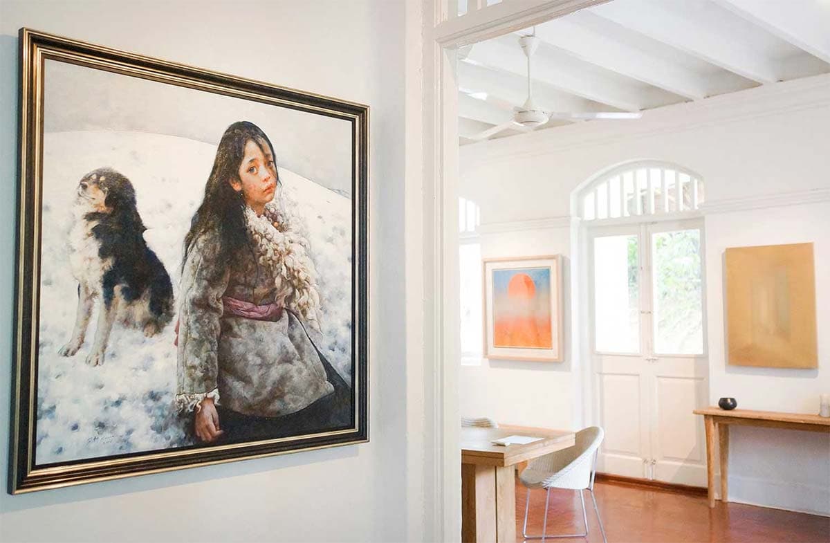 An advisor considering works on a gallery wall