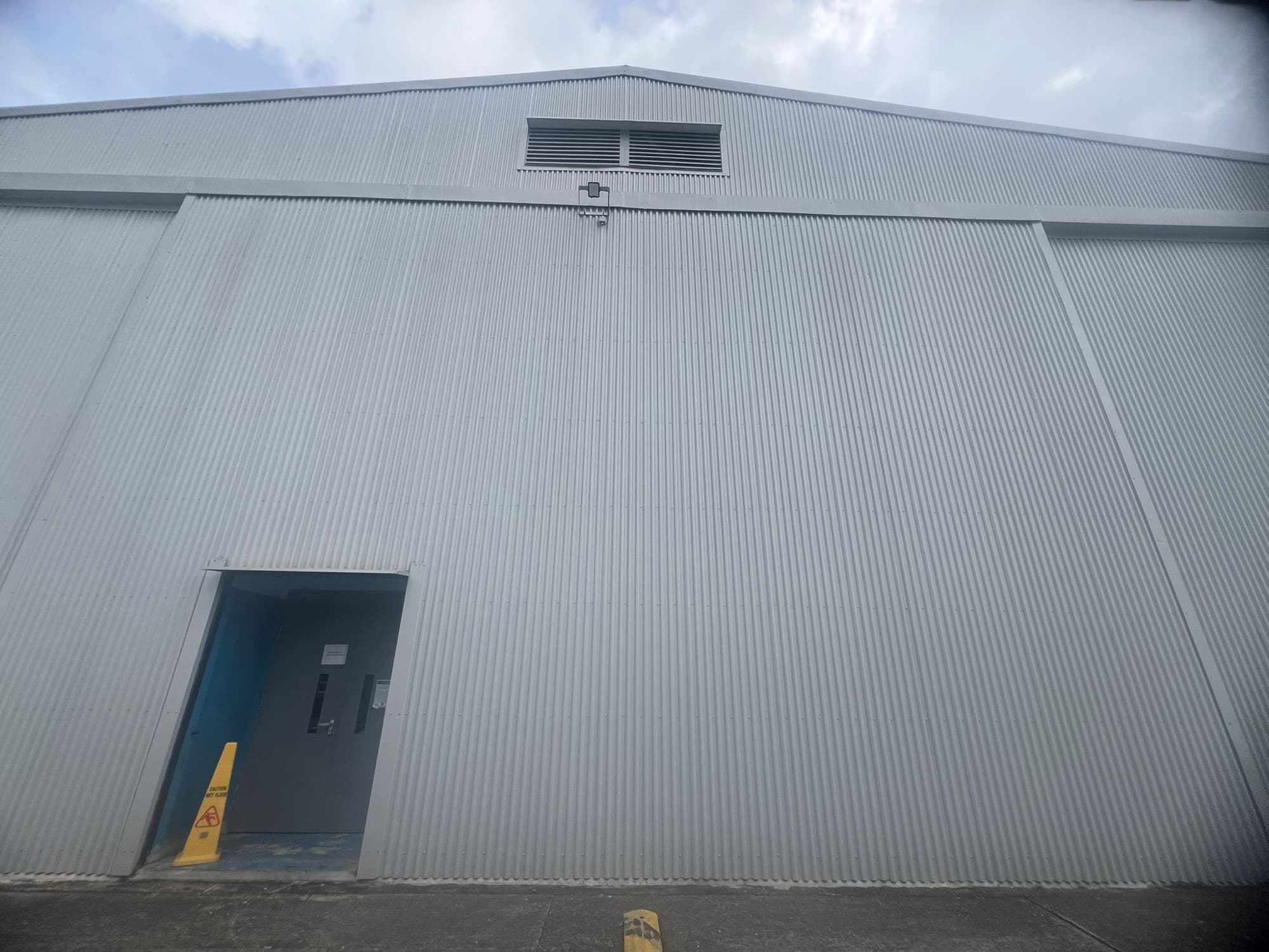 A blank corrugated steel facade before the mural was painted